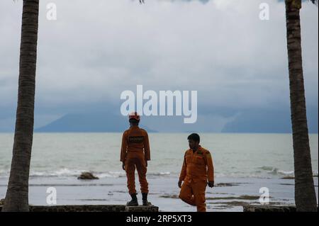 Actualités Themen der Woche KW52 Actualités Bilder des Tages (181226) -- BANTEN, 26 décembre 2018 -- des sauveteurs observent le volcan Anak Krakatau depuis la plage d'Anyer à Banten Provinece, Indonésie, le 26 décembre 2018. L’éruption du volcan a provoqué des glissements de terrain sous-marins et a entraîné un tsunami qui a tué plus de 400 personnes et en a blessé au moins 1 400 autres jusqu’à présent. Les équipes de secours se sont efforcées d ' atteindre les zones isolées touchées par le tsunami en Indonésie, où l ' on pense que davantage de victimes demeureraient sous les décombres. INDONÉSIE-BANTEN-VOLCAN ANAK KRAKATAU-ACTIVITÉ VERIXSANOVRI PUBLICATIONXNOTXINXCHN Banque D'Images