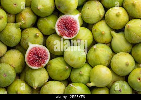 Pile de figues vertes fraîches, douces et au miel, une coupe ouverte. Figues oganiques vertes crues prêtes à manger. Banque D'Images