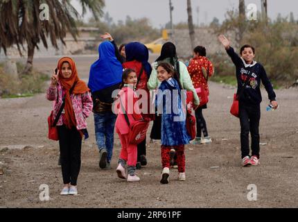 (181230) -- Bagdad, 30 décembre 2018 -- des enfants déplacés partent pour leur foyer après une journée d étude sur le bus Hope à Bagdad, capitale de l Irak, le 27 décembre 2018. Dans un bidonville oublié au sud-est de Bagdad, capitale de l'Irak, une lueur d'espoir brille dans le cœur et l'esprit de dizaines d'enfants déplacés à l'intérieur du pays alors qu'une organisation non gouvernementale (ONG) transformait un grand vieux bus en école mobile. Il est nommé Hope bus, dont les sièges ont été enlevés et remplacés par des pupitres d'école pour pas moins de 50 élèves, et a été meublé avec des rideaux colorés, des haut-parleurs, un téléviseur et un tableau noir. Banque D'Images