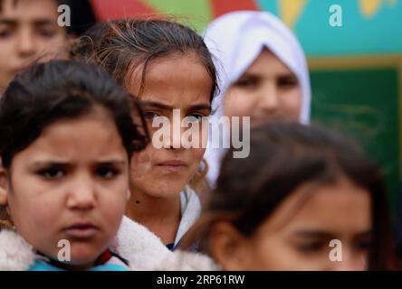 (181230) -- Bagdad, 30 décembre 2018 -- des enfants déplacés sont vus à côté du bus de l'espoir à Bagdad, capitale de l'Irak, le 27 décembre 2018. Dans un bidonville oublié au sud-est de Bagdad, capitale de l'Irak, une lueur d'espoir brille dans le cœur et l'esprit de dizaines d'enfants déplacés à l'intérieur du pays alors qu'une organisation non gouvernementale (ONG) transformait un grand vieux bus en école mobile. Il est nommé Hope bus, dont les sièges ont été enlevés et remplacés par des pupitres d'école pour pas moins de 50 élèves, et a été meublé avec des rideaux colorés, des haut-parleurs, un téléviseur et un tableau noir. Les enfants dans le bus Banque D'Images