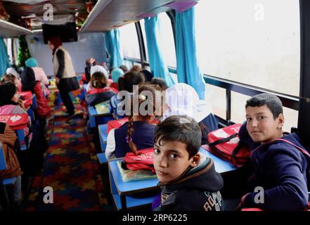 (181230) -- Bagdad, 30 décembre 2018 -- des enfants déplacés prennent leur classe à bord du bus Hope à Bagdad, capitale de l'Irak, le 27 décembre 2018. Dans un bidonville oublié au sud-est de Bagdad, capitale de l'Irak, une lueur d'espoir brille dans le cœur et l'esprit de dizaines d'enfants déplacés à l'intérieur du pays alors qu'une organisation non gouvernementale (ONG) transformait un grand vieux bus en école mobile. Il est nommé Hope bus, dont les sièges ont été enlevés et remplacés par des pupitres d'école pour pas moins de 50 élèves, et a été meublé avec des rideaux colorés, des haut-parleurs, un téléviseur et un tableau noir. Les enfants dans le Banque D'Images