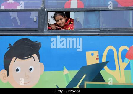 (181230) -- Bagdad, 30 décembre 2018 -- Une fille regarde par une fenêtre dans le bus de l'espoir à Bagdad, capitale de l'Irak, le 27 décembre 2018. Dans un bidonville oublié au sud-est de Bagdad, capitale de l'Irak, une lueur d'espoir brille dans le cœur et l'esprit de dizaines d'enfants déplacés à l'intérieur du pays alors qu'une organisation non gouvernementale (ONG) transformait un grand vieux bus en école mobile. Il est nommé Hope bus, dont les sièges ont été enlevés et remplacés par des pupitres d'école pour pas moins de 50 élèves, et a été meublé avec des rideaux colorés, des haut-parleurs, un téléviseur et un tableau noir. Les enfants dans le bus Banque D'Images