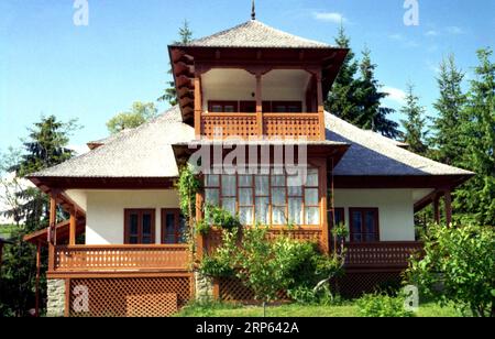 Comté de Neamt, Roumanie, env. 2000. Belle maison traditionnelle avec porche en bois enveloppant et balcon. Banque D'Images