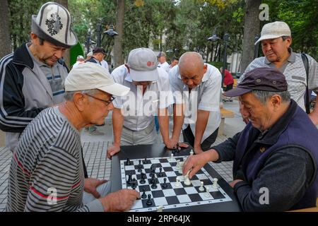 Bichkek, Kirghizistan - 4 septembre 2023 : des gens jouant aux échecs dans un parc à Bichkek, Kirghizistan. Banque D'Images