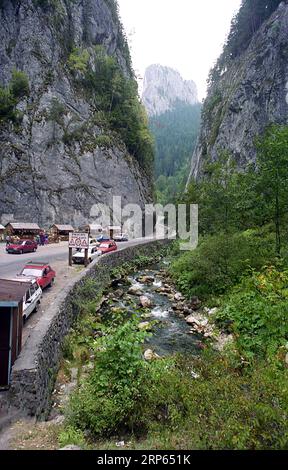 Comté de Neamt, Roumanie, env. 1994. La route nationale DN12C passant par les Gorges de Bicaz dans le Parc National des Monts Hășmaș. Les véhicules se sont arrêtés dans une zone avec des boutiques de souvenirs. Banque D'Images