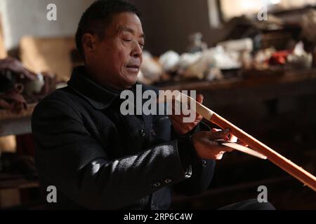 (190109) -- LINYI, 9 janvier 2019 -- le villageois Gao Zhenbao vérifie le poteau d'Erhu, un instrument chinois à deux cordes cintré dans le village de Yuequan de la ville de Miaoshan dans la ville de Linyi, dans la province du Shandong de l'est de la Chine, le 8 janvier 2019. Yuequan est célèbre pour son Erhu fait à la main, avec plus de 90 ménages qui lui sont dédiés dans le village.) CHINE-SHANDONG-LINYI-FOLK ERHU MAKER (CN) ZHANGXCHUNLEI PUBLICATIONXNOTXINXCHN Banque D'Images