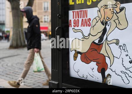 (190111) -- PÉKIN, 11 janvier 2019 -- Un homme marche près d'une affiche célébrant le 90e anniversaire des aventures de Tintin à Bruxelles, Belgique, le 10 janvier 2019. ) PHOTOS XINHUA DU JOUR ZhengxHuansong PUBLICATIONxNOTxINxCHN Banque D'Images