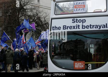 (190115) -- LONDRES, 15 janvier 2019 -- les manifestants pro-Brexit et anti-Brexit brandissent des drapeaux et des pancartes alors qu'un bus portant des slogans pro-Brexit passe devant les chambres du Parlement, à Londres, en Grande-Bretagne, le 15 janvier. 2019. Un vote parlementaire différé sur l ' accord sur le Brexit est prévu aujourd ' hui. ) ROYAUME-UNI-LONDRES-BREXIT TimxIreland PUBLICATIONxNOTxINxCHN Banque D'Images