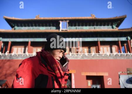 (190117) -- PÉKIN, 17 janv. 2019 (Xinhua) -- le livreur Yang Hongyi appelle les clients pour prendre des colis devant une porte de la Cité interdite à Pékin, capitale de la Chine, le 15 janvier 2019. En près de trois ans de travail comme livreur dans les environs de la Cité interdite, Yang Hongyi, 44 ans, a livré plus de 100 000 colis sans même un avis négatif de ses clients. Yang travaille de l'aube à la nuit chaque jour, au cours de laquelle il doit livrer environ 200 colis et faire environ 200 appels aux clients. À l'approche de la fête du printemps, Yang doit livrer 100 paquets supplémentaires Banque D'Images