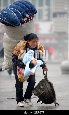 (190120) -- PÉKIN, 20 janv. 2019 (Xinhua) -- Une femme portant de lourds bagages tente d'attraper son train avec un bébé au bras à la gare de Nanchang à Nanchang, dans la province de Jiangxi, dans l'est de la Chine, le 30 janvier 2010. Retourner dans les villes d'origine reste la partie la plus importante du Festival du Printemps chinois. Que ce soit en voiture autonome, en train ou en avion, les homecomings et les réunions de famille sont une priorité pour de nombreux Chinois. La ruée annuelle autour du festival, connue sous le nom de chunyun, met souvent à l épreuve le système de transport du pays. Les autorités de transport chinoises sont occupées à se préparer Banque D'Images