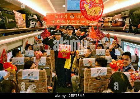 (190128) -- PÉKIN, 28 janv. 2019 (Xinhua) -- la police des chemins de fer et les passagers réagissent dans un train à grande vitesse alors qu'ils célèbrent le festival Xiaonian, le 23e jour du dernier mois lunaire précédant le festival du printemps, le 28 janvier 2019. Xiaonian tombe le 23e ou 24e jour du dernier mois du calendrier lunaire traditionnel chinois, marquant le début du compte à rebours du nouvel an lunaire chinois. (Xinhua/Zhang Yuan) CHINA-RAILWAY-SPRING FESTIVAL (CN) PUBLICATIONxNOTxINxCHN Banque D'Images