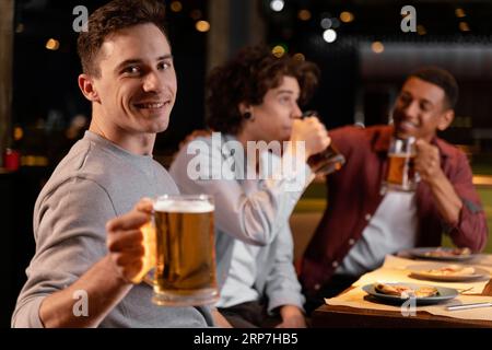 Les hommes de taille moyenne boivent de la bière Banque D'Images