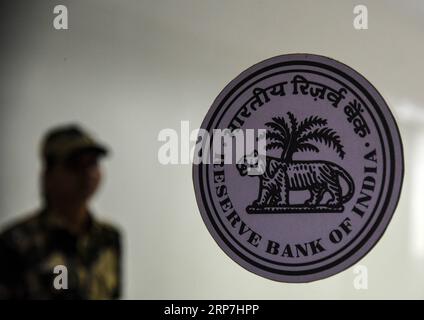 (190207) -- MUMBAI, 7 février 2019 (Xinhua) -- Un membre du personnel de sécurité monte la garde près du logo de la Reserve Bank of India (RBI) à l'intérieur de son siège à Mumbai, en Inde, le 7 février 2019. Banque centrale de l Inde - la Banque de réserve de l Inde (RBI) a réduit jeudi le taux de pension, ou le taux d intérêt auquel elle prête de l argent aux banques, d un marginal 25 points de base. Le nouveau taux de pension s'élève maintenant à 6,25 pour cent contre 6,50 pour cent auparavant. (Xinhua/Stringer) INDIA-MUMBAI-RBI GOUVERNEUR-CONFÉRENCE DE PRESSE PUBLICATIONxNOTxINxCHN Banque D'Images