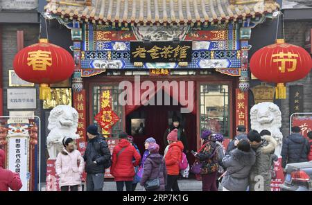 (190208) -- PÉKIN, 8 février 2019 (Xinhua) -- les touristes passent devant Laoshe Teahouse, rue Qianmen à Pékin, capitale de la Chine, le 8 février 2019. Les touristes ont visité la rue Qianmen pour profiter du paysage et des délices ici pendant les vacances de la fête du printemps. (Xinhua/Li Xin) CHINE-PÉKIN-TOURISME (CN) PUBLICATIONxNOTxINxCHN Banque D'Images