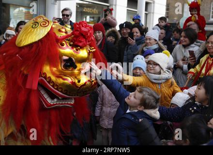 (190210) -- BEIJING, 10 février 2019 -- des enfants touchent des parties d'un costume utilisé dans une représentation de danse du lion lors d'une célébration du nouvel an lunaire chinois au Duke of York Square à Londres, Grande-Bretagne, le 9 février 2019.) PHOTOS XINHUA DU JOUR HanxYan PUBLICATIONxNOTxINxCHN Banque D'Images