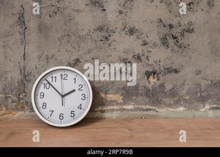 Horloge bureau en bois contre le mur patiné Banque D'Images