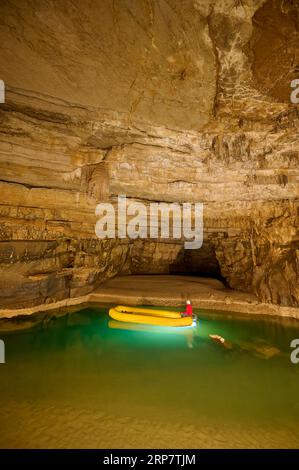 Grotte karstique, lac, canot en caoutchouc, spéléologue, Krizna jama, Cerknica, Carniola, Slovénie Banque D'Images