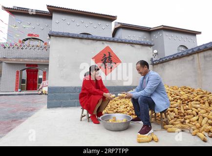 (190212) -- PÉKIN, 12 février 2019 (Xinhua) -- Un couple nouvellement marié manipule des cors dans le village de Xia an du comté de Quyang, province du Hebei, dans le nord de la Chine, le 20 octobre 2018. En raison de conditions environnementales difficiles, Xia an a longtemps été un village moins développé dans le Hebei. De 2016 à 2017, un programme de relocalisation a été mis en œuvre pour construire des maisons dans des endroits plus aisés à des fins de réduction de la pauvreté. De nombreux villageois ont emménagé dans leurs nouvelles maisons depuis la fin du programme en juillet 2017. La Chine continuera à œuvrer énergiquement pour réduire la pauvreté et sortir pas moins de dix millions de personnes de la pauvreté Banque D'Images