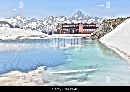 Photo avec réduction de la saturation de la plage dynamique HDR du col de montagne alpine route de montagne passe de route alpine avec neige et glace sur le lac de montagne Banque D'Images