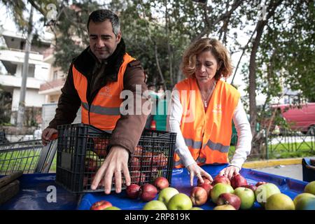 (190214) -- ATHÈNES, 14 février 2019 -- des bénévoles de l'organisation à but non lucratif Boroume collectent des pommes sur un marché de rue dans la municipalité de Chalandri, une banlieue nord d'Athènes, Grèce, le 12 février 2019. Boroume (ce qui signifie que nous pouvons en grec) a été créé en tant qu'organisation à but non lucratif en janvier 2012. En sept ans, il a aidé à sauver et à offrir aux nécessiteux au moins 29 millions de portions de nourriture et continue de travailler sans arrêt chaque jour dans cette direction, membre fondateur Alexandros Theodoridis a déclaré à Xinhua le 12 février.) POUR ALLER AVEC la fonctionnalité : ONG grecque lutte toujours contre le gaspillage alimentaire, la malnutrition, le pontage d Banque D'Images