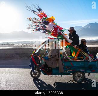 (190216) -- LHASSA, 16 février 2019 (Xinhua) -- Un homme tenant de nouveaux drapeaux de prière est vu sur un véhicule à Lhassa, dans la région autonome du Tibet du sud-ouest de la Chine, le 6 février 2019. Le nouvel an tibétain, connu sous le nom de Losar, est le festival le plus important du calendrier tibétain. Cette année, Losar est tombé le 5 février et a coïncidé avec le Festival du printemps. Losar est un temps pour les réunions de famille. Il est marqué par des rituels religieux, de longues prières, des courses de chevaux, des rassemblements familiaux et des fêtes. Alors que le festival approche, les gens vont faire du shopping, faire un peu de nettoyage et décorer leurs maisons populaires. Les familles se régalent de la nourriture tibétaine. Les femmes font Banque D'Images
