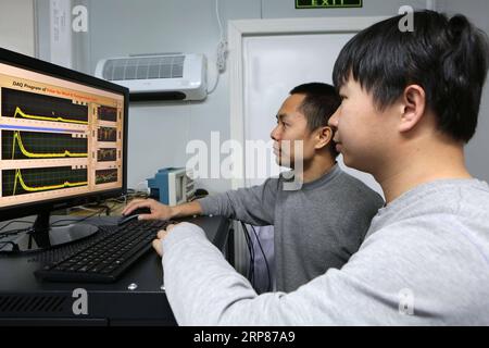 (190220) -- A BORD DE XUELONG, 20 février 2019 (Xinhua) -- des membres de la 35e mission de recherche chinoise en Antarctique vérifient les données d'un système lidar Doppler à fluorescence à la station Zhongshan, une base de recherche chinoise en Antarctique, le 11 février 2019. Des chercheurs chinois ont installé et testé un système lidar Doppler à fluorescence dans une base de recherche en Antarctique lors d’une mission qui vient de se terminer la semaine dernière et qui se dirige maintenant vers leur pays. Le fonctionnement du système à la station Zhongshan leur avait permis d'observer simultanément la température et le champ de vent tridimensionnel dans la région atmosphérique mesopause A. Banque D'Images