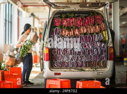 (190220) -- KUNMING, 20 février 2019 (Xinhua) -- Une femme charge une voiture de rose sur un marché aux fleurs à Dounan, dans la province du Yunnan, dans le sud-ouest de la Chine, le 12 février 2019. Les fleurs fraîches emballées à Kunming du Yunnan seront disponibles à la vente sur un marché de Bangkok en moins de 40 heures grâce à la Kunming-Bangkok Expressway. Le climat chaud du Yunnan permet aux fleurs de toutes sortes de fleurir en toutes saisons. Dounan, en tant que plus grand marché de gros de fleurs fraîches de Chine, exporte chaque jour plus de 500 variétés et 40 catégories de fleurs dans plus de 50 pays et régions, dont 20 à 30 pour cent sont vendus Banque D'Images