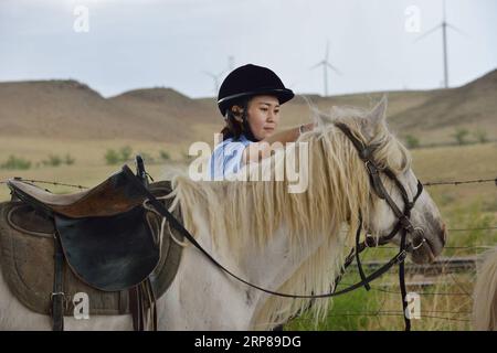 (190223) -- BEIJING, 23 février 2019 (Xinhua) -- Une policière à cheval prépare son cheval alors qu'elle patrouillait le long d'un chemin de fer à Xilinhot, dans la région autonome de Mongolie intérieure du nord de la Chine, le 7 juin 2018. La Chine a interdit les pratiques de discrimination fondée sur le sexe dans le recrutement afin de stimuler les opportunités de carrière pour les femmes. Aucune exigence de genre ne devrait être incluse dans les plans de recrutement ou les entretiens, selon un document publié par le Ministère des ressources humaines et de la sécurité sociale et huit autres organismes gouvernementaux. Il est également interdit de poser des questions sur l'état matrimonial ou de fécondité des candidates dur Banque D'Images
