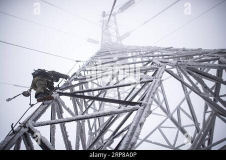 (190223) -- WUHAN, 23 février 2019 -- une photo prise le 12 février 2019 montre un travailleur d'urgence escaladant la tour de transmission de puissance pour les réparations urgentes dans la région montagneuse de Wuhan, capitale de la province du Hubei en Chine centrale. Une équipe d'électriciens a été envoyée pour réparer un fil haute tension qui a été cassé en raison de l'accumulation d'une épaisse couche de glace. Après une journée de travail sur la tour de transmission de plus de 40 mètres de puissance dans de mauvaises conditions météorologiques, l'équipe a réussi à réparer le système électrique défaillant qui a réduit la vitesse des trains, causant des retards pendant le pic de voyage après les vacances. Cette année, Printemps F Banque D'Images