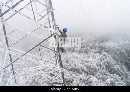 (190223) -- WUHAN, 23 février 2019 -- une photo prise le 12 février 2019 montre l'électricien Wang Chaolin escaladant la tour de transmission de puissance pour des réparations urgentes dans la région montagneuse de Wuhan, capitale de la province du Hubei en Chine centrale. Une équipe d'électriciens a été envoyée pour réparer un fil haute tension qui a été cassé en raison de l'accumulation d'une épaisse couche de glace. Après une journée de travail sur la tour de transmission de plus de 40 mètres de puissance dans de mauvaises conditions météorologiques, l'équipe a réussi à réparer le système électrique défaillant qui a réduit la vitesse des trains, causant des retards pendant le pic de voyage après les vacances. Printemps de cette année Banque D'Images