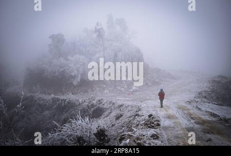 (190223) -- WUHAN, 23 février 2019 -- une photo prise le 12 février 2019 montre un électricien participant aux réparations urgentes dans la région montagneuse de Wuhan, capitale de la province du Hubei en Chine centrale. Une équipe d'électriciens a été envoyée pour réparer un fil haute tension qui a été cassé en raison de l'accumulation d'une épaisse couche de glace. Après une journée de travail sur la tour de transmission de plus de 40 mètres de puissance dans de mauvaises conditions météorologiques, l'équipe a réussi à réparer le système électrique défaillant qui a réduit la vitesse des trains, causant des retards pendant le pic de voyage après les vacances. Cette année, la ruée vers les voyages au Spring Festival a commencé Banque D'Images