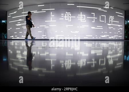 (190308) -- PÉKIN, 8 mars 2019 (Xinhua) -- Un homme passe devant une pancarte pour Shanghai E-port à Shanghai, dans l'est de la Chine, 12 août 2018. (Xinhua/Jin Liwang) titres de Xinhua : la loi chinoise sur les investissements étrangers inaugure un nouveau chapitre de l'ouverture de PUBLICATIONxNOTxINxCHN Banque D'Images