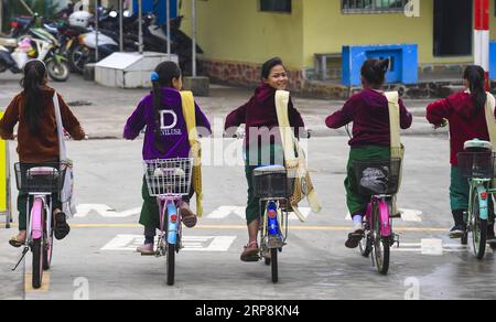 (190310) -- PÉKIN, 10 mars 2019 (Xinhua) -- des étudiants du Myanmar rentrent chez eux en vélo après avoir étudié à l'école primaire de Yinjing dans le village de Yinjing à Ruili, dans la province du Yunnan, dans le sud-ouest de la Chine, le 8 mars 2019. L'école primaire de Yinjing est située à la frontière entre la Chine et le Myanmar et compte un total de 135 élèves, dont 36 étudiants du Myanmar. (Xinhua/Li Xiaoguo) PHOTOS XINHUA DU JOUR PUBLICATIONxNOTxINxCHN Banque D'Images