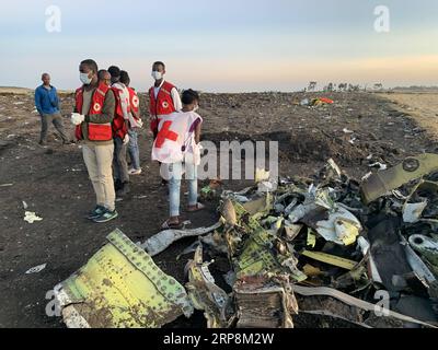 (190310) -- ADDIS-ABEBA, 10 mars 2019 (Xinhua) -- des sauveteurs travaillent à côté de l'épave d'un avion d'Ethiopian Airlines sur le site de l'accident, à environ 50 km à l'est d'Addis-Abeba, capitale de l'Éthiopie, le 10 mars 2019. Les 157 personnes à bord du vol d'Ethiopian Airlines ont été confirmées mortes, la compagnie aérienne la plus florissante d'Afrique ayant été témoin du pire incident de son histoire. L’incident de dimanche, qui impliquait un Boeing 737-800 MAX, s’est produit quelques minutes après le décollage de l’avion de l’aéroport international Addis Ababa Bole à destination de Nairobi, au Kenya. Il s'est écrasé autour de la ville de Bishoftu, a déclaré la compagnie aérienne. (Xinhua/W Banque D'Images