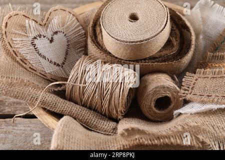 Morceaux de toile de jute et bobines de ficelle sur table en bois, gros plan Banque D'Images