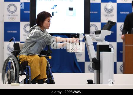 (190316) -- BEIJING, 16 mars 2019 (Xinhua) -- le robot de soutien humain, qui peut être utilisé aux Jeux olympiques et paralympiques de Tokyo 2020, livre des marchandises à un membre du personnel en fauteuil roulant à Tokyo, Japon, le 15 mars 2019. Le comité organisateur de Tokyo 2020 a annoncé vendredi le lancement de son nouveau Tokyo 2020 robot Project. (Xinhua/du Xiaoyi) PHOTOS XINHUA DU JOUR PUBLICATIONxNOTxINxCHN Banque D'Images