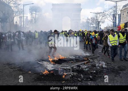 Paris, Erneute Unruhen nach Gelbwesten-Protesten (190316) -- PARIS, le 16 mars 2019 -- des manifestants gilets jaunes brûlent des barrières sur l'avenue des champs-Elysées à Paris, France, le 16 mars 2019. La police française a arrêté plus de 200 personnes samedi après que des violences aient éclaté à Paris lors d'une nouvelle manifestation du mouvement Yellow Vest. FRANCE-PARIS- GILET JAUNE -PROTEST AlexandrexKarmen PUBLICATIONxNOTxINxCHN Banque D'Images