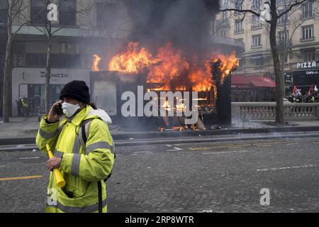 (190316) -- PARIS, le 16 mars 2019 -- Un manifestant gilet jaune marche près d'un magasin en feu sur l'avenue des champs-Elysées à Paris, France, le 16 mars 2019. La police française a arrêté plus de 200 personnes samedi après que des violences aient éclaté à Paris lors d'une nouvelle manifestation du mouvement Yellow Vest. FRANCE-PARIS- GILET JAUNE -PROTEST AlexandrexKarmen PUBLICATIONxNOTxINxCHN Banque D'Images