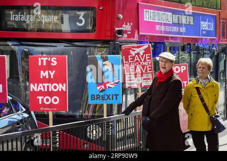 (190319) -- LONDRES, 19 mars 2019 -- les gens marchent devant les pancartes des manifestants anti-Brexit devant les chambres du Parlement à Londres, en Grande-Bretagne, le 19 mars 2019. Downing Street a confirmé mardi que la première ministre britannique Theresa May écrira au président du Conseil européen Donald Tusk pour demander que le départ de la Grande-Bretagne du bloc soit retardé. GRANDE-BRETAGNE-LONDRES-BREXIT-MANIFESTATION StephenxChung PUBLICATIONxNOTxINxCHN Banque D'Images