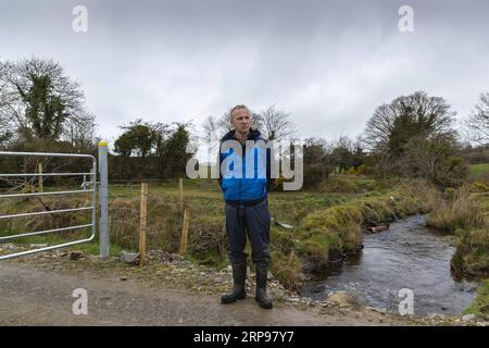 (190328) -- DERRY, 28 mars 2019 (Xinhua) -- Brian Renaghan, se tient à côté de la frontière irlandaise qui divise sa ferme en deux, une moitié dans le comté d'Armagh en Irlande du Nord au Royaume-Uni et l'autre dans le comté de Monaghan en République d'Irlande le 19 mars 2019. La possibilité imminente d’une frontière irlandaise dure qui pourrait être créée par le Brexit cause une agonie aux habitants de Derry, une ville frontalière d’Irlande du Nord qui n’est pas peu familière avec les jours sombres de division et de violence. POUR ALLER AVEC Spotlight : la ville d'Irlande du Nord se méfie d'une possible frontière dure alors que le Brexit se profile (Xinhua/Han Yan) UK-DERRY-BORDER-BRE Banque D'Images