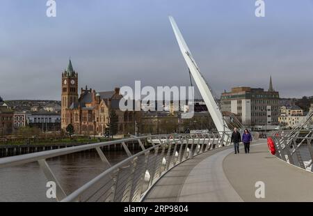 (190328) -- DERRY, 28 mars 2019 (Xinhua) -- les gens marchent sur le pont de la paix à Derry, une ville frontalière d'Irlande du Nord, au Royaume-Uni, le 20 mars 2019. La possibilité imminente d’une frontière irlandaise dure qui pourrait être créée par le Brexit cause une agonie aux habitants de Derry, une ville frontalière d’Irlande du Nord qui n’est pas peu familière avec les jours sombres de division et de violence. POUR ALLER AVEC Spotlight : la ville d'Irlande du Nord se méfie d'une possible frontière dure alors que le Brexit se profile (Xinhua/Han Yan) UK-DERRY-BORDER-BREXIT PUBLICATIONxNOTxINxCHN Banque D'Images