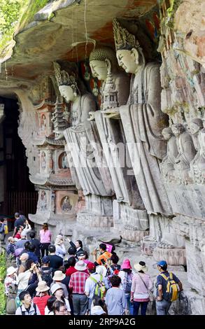 (190330) -- CHONGQING, 30 mars 2019 (Xinhua) -- les touristes regardent des sculptures rupestres dans la région pittoresque de Dazu Rock Carvings dans le district de Dazu à Chongqing, dans le sud-ouest de la Chine, le 29 mars 2019. Les sculptures datant du 9e au 13e siècles ont été inscrites sur la liste du patrimoine mondial par l’UNESCO en 1999. (Xinhua/Liu Chan) CHINA-CHONGQING-DAZU ROCK CARVING-TOURISM (CN) PUBLICATIONxNOTxINxCHN Banque D'Images