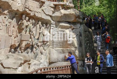 (190330) -- CHONGQING, 30 mars 2019 (Xinhua) -- les touristes regardent des sculptures rupestres dans la région pittoresque de Dazu Rock Carvings dans le district de Dazu à Chongqing, dans le sud-ouest de la Chine, le 29 mars 2019. Les sculptures datant du 9e au 13e siècles ont été inscrites sur la liste du patrimoine mondial par l’UNESCO en 1999. (Xinhua/Liu Chan) CHINA-CHONGQING-DAZU ROCK CARVING-TOURISM (CN) PUBLICATIONxNOTxINxCHN Banque D'Images