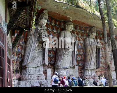 (190330) -- CHONGQING, 30 mars 2019 (Xinhua) -- les touristes regardent des sculptures rupestres dans la région pittoresque de Dazu Rock Carvings dans le district de Dazu à Chongqing, dans le sud-ouest de la Chine, le 29 mars 2019. Les sculptures datant du 9e au 13e siècles ont été inscrites sur la liste du patrimoine mondial par l’UNESCO en 1999. (Xinhua/Liu Chan) CHINA-CHONGQING-DAZU ROCK CARVING-TOURISM (CN) PUBLICATIONxNOTxINxCHN Banque D'Images