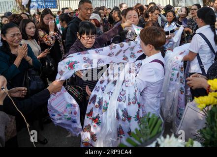 (190402) -- XICHANG, 2 avril 2019 (Xinhua) -- les gens présentent hada, un tissu de soie cérémonial pour montrer leur respect, lors d'une cérémonie de deuil spontanée pour rendre hommage à ceux qui ont perdu la vie en combattant le feu de forêt dans un salon funéraire dans la ville de Xichang, dans la province du Sichuan, au sud-ouest de la Chine, le 2 avril 2019. Un incendie qui a tué 30 personnes et englouti environ 15 hectares de forêt dans la province du Sichuan du sud-ouest de la Chine a été éteint mardi, ont déclaré les autorités locales. Trente personnes, dont 27 pompiers et trois habitants, ont perdu la vie en combattant l'incendie. (Xinhua/Zhang Chaoqun) CHINE Banque D'Images