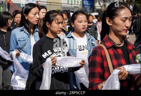 (190402) -- XICHANG, 2 avril 2019 (Xinhua) -- les gens présentent hada, un tissu de soie cérémonial pour montrer leur respect, lors d'une cérémonie de deuil spontanée pour rendre hommage à ceux qui ont perdu la vie en combattant le feu de forêt dans un salon funéraire dans la ville de Xichang, dans la province du Sichuan, au sud-ouest de la Chine, le 2 avril 2019. Un incendie qui a tué 30 personnes et englouti environ 15 hectares de forêt dans la province du Sichuan du sud-ouest de la Chine a été éteint mardi, ont déclaré les autorités locales. Trente personnes, dont 27 pompiers et trois habitants, ont perdu la vie en combattant l'incendie. (Xinhua/Zhang Chaoqun) CHINE Banque D'Images