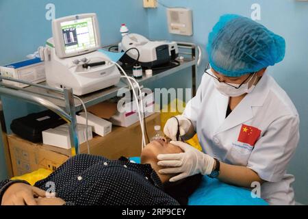 (190402) -- PHNOM PENH, 2 avril 2019 (Xinhua) -- Liao Shaoyan (droite), infirmière du premier hôpital affilié de l'Université médicale du Guangxi, effectue des examens préopératoires pour Sum Meyle avant une opération de cataracte à l'hôpital provincial de Kampong Cham à Kampong Cham, Cambodge, le 15 mars 2019. Sum Meyle, 36 ans, est une mère célibataire avec cinq enfants. Pour aider à améliorer leurs conditions financières, deux des filles de Meyle travaillent maintenant dans la capitale Phnom Penh tandis que deux de ses fils vivent dans une maison de retraite pour enfants. Meyle vit maintenant dans un bidonville loué avec sa plus jeune fille. Meyle h Banque D'Images