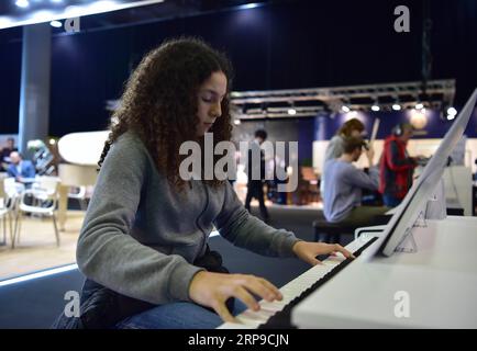 (190402) -- FRANCFORT, 2 avril 2019 (Xinhua) -- Une fille joue du piano numérique exposé par la compagnie Kurzweil à la Musikmesse à Francfort, Allemagne, le 2 avril 2019. L'événement de quatre jours Musikmesse, le salon européen leader de l'industrie de la musique, a débuté mardi. (Xinhua/lu Yang) ALLEMAGNE-FRANCFORT-SALON-MUSIKMESSE PUBLICATIONxNOTxINxCHN Banque D'Images