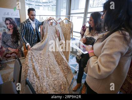 (190407) -- VANCOUVER, le 7 avril 2019 -- les gens regardent une robe de mariée de style indien lors de la 4e semaine de la mode nuptiale à Vancouver, Canada, le 6 avril 2019. La Bridal Fashion week est un spectacle de mariage d'Asie du Sud qui met en vedette des créateurs de mariage, des bijoutiers et des vendeurs de mariage, qui a débuté samedi.) CANADA-VANCOUVER-BRIDAL FASHION WEEK LiangxSen PUBLICATIONxNOTxINxCHN Banque D'Images