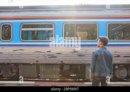 (190412) -- BANGKOK, 12 avril 2019 (Xinhua) -- Anupat Tiprat observe le passage d'un train à la gare de Hua Hin à Bangkok, Thaïlande, le 15 mars 2019. Anupat Tiprat, vingt et un ans, rêve de devenir conducteur de train dans son pays natal, la Thaïlande. Plus tard ce mois-ci, il se rendra dans la ville de Tianjin, dans le nord de la Chine, pour y apprendre l’entretien et la conduite des trains pendant trois ans. A SUIVRE : la coopération ferroviaire Chine-Thaïlande rapproche la jeunesse thaïlandaise de son rêve de conducteur de train (Xinhua/Yang Zhou) THAÏLANDE-BANGKOK-CHINE-CHEMIN DE FER-JEUNESSE-RÊVE PUBLICATIONxNOTxINxCHN Banque D'Images
